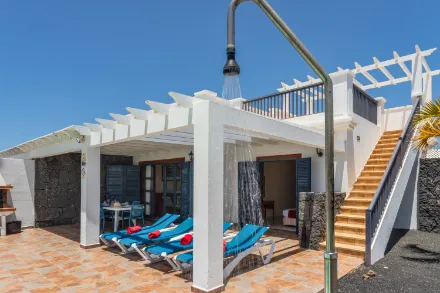 Terraza con ducha exterior y tumbonas en villa vacacional de Lanzarote, Villas Susaeta